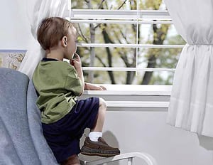 Child looking out a window thoughtfully.