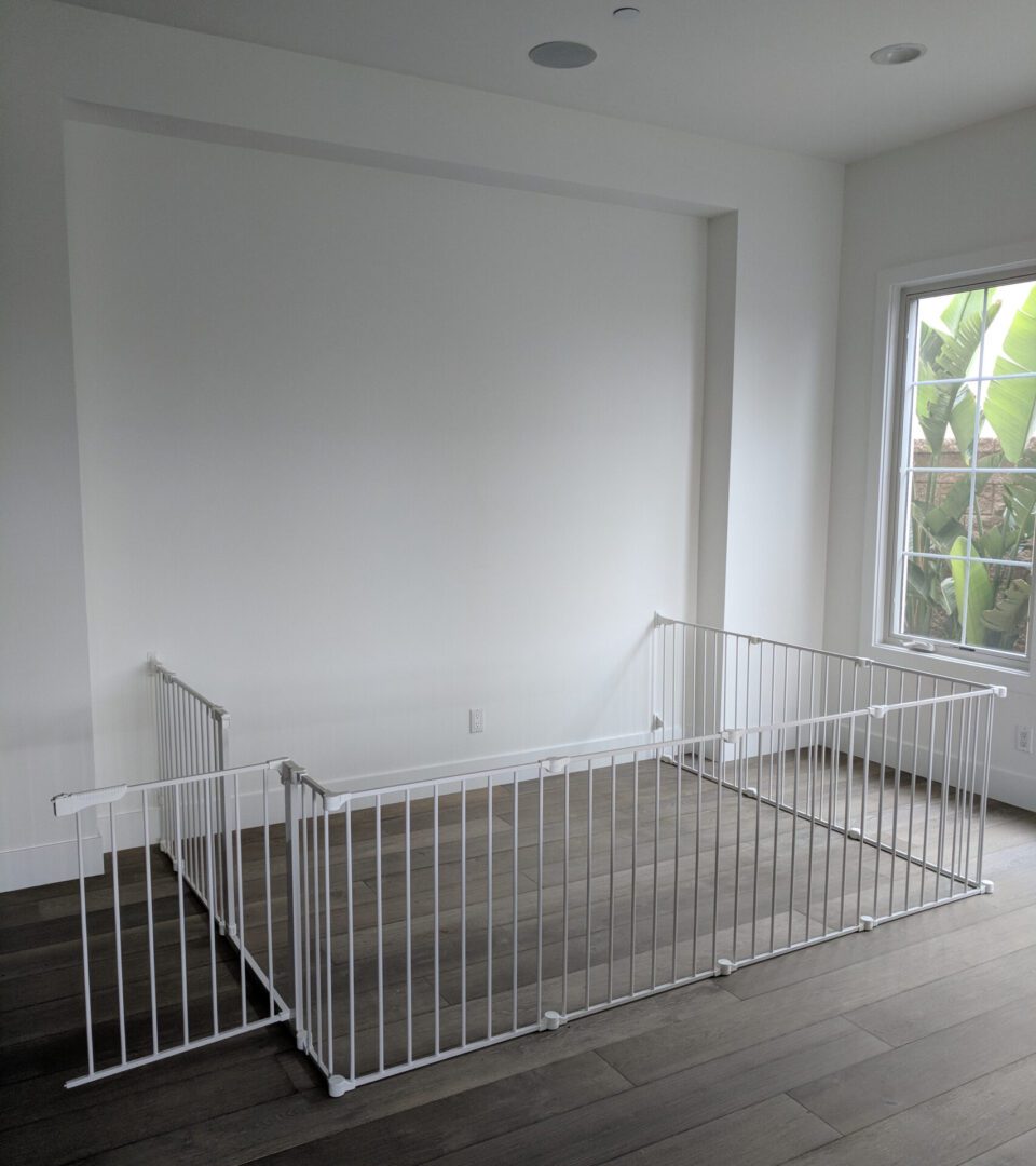 White baby gate in empty room corner.