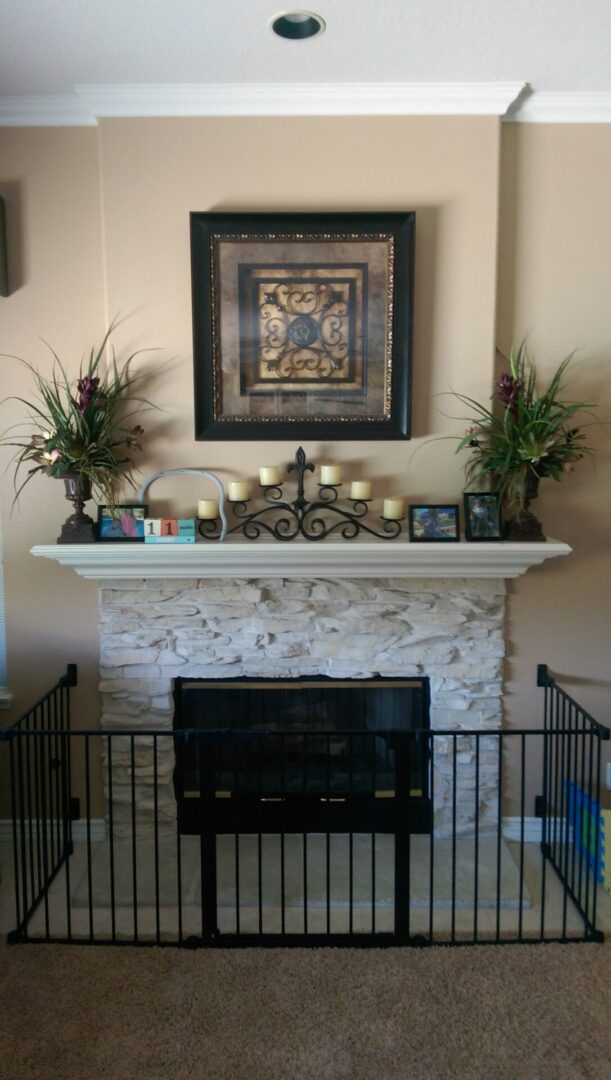 Decorative fireplace with artwork and plants.