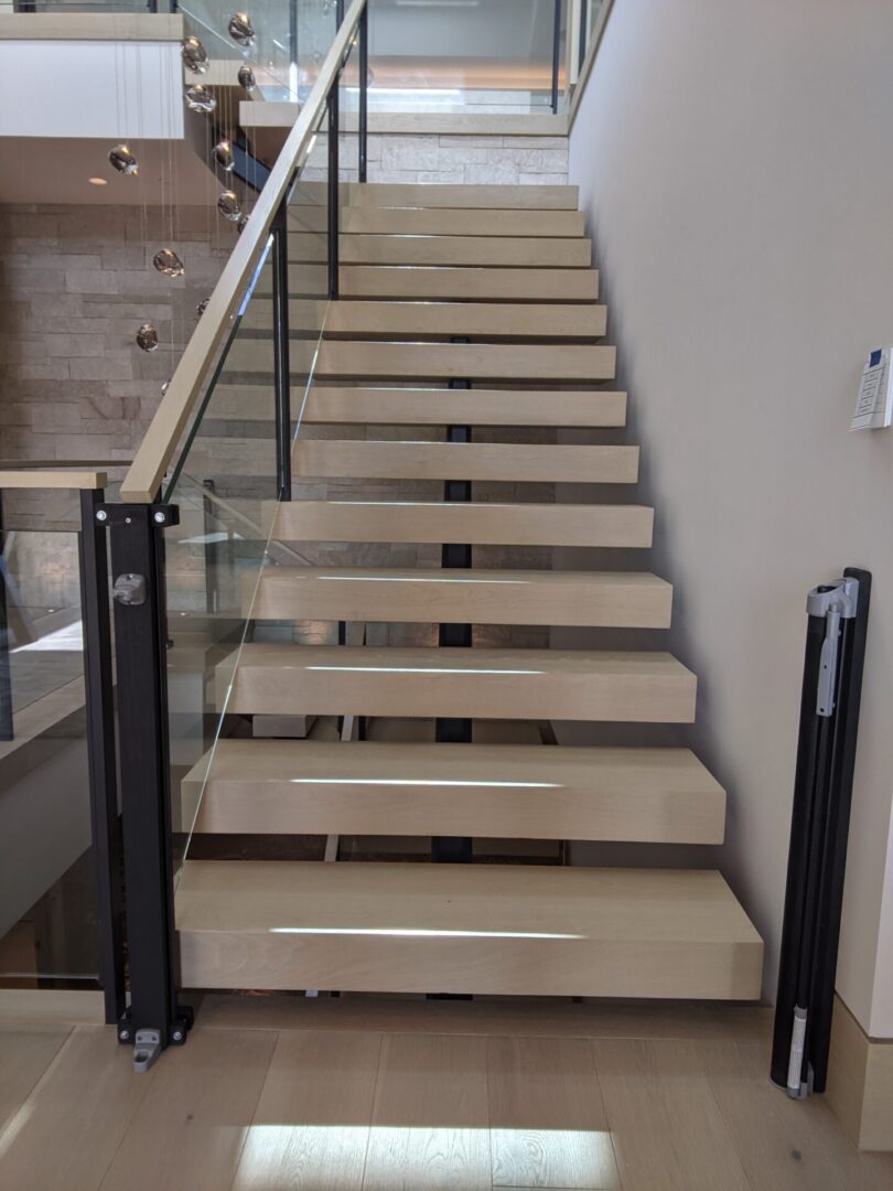 Modern wooden staircase with glass railing.
