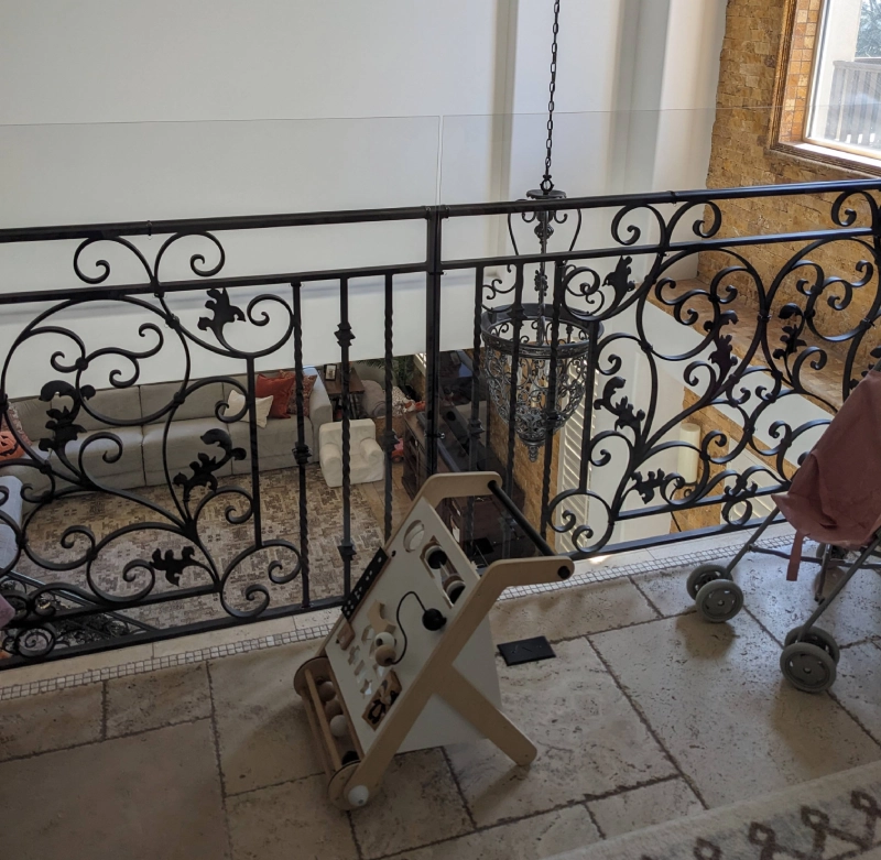 Ornate balcony railing overlooking living area.